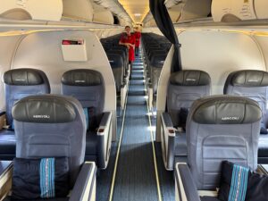 Review: Aero Dili A320 Business Class a woman standing in the middle of an airplane