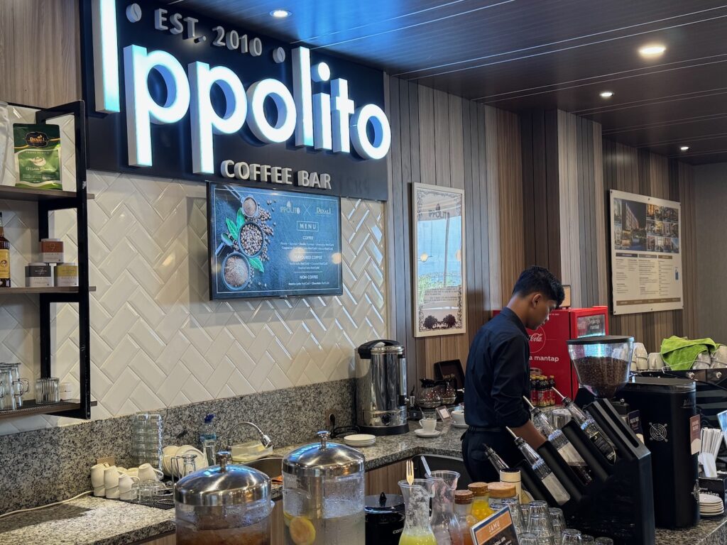 a man standing behind a counter in a coffee shop