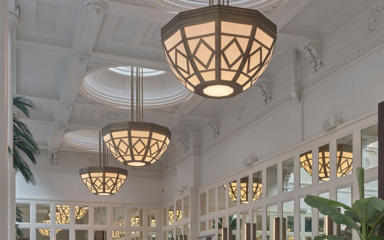 Tall panelled ceiling in white with structural pendants and mirrored walls