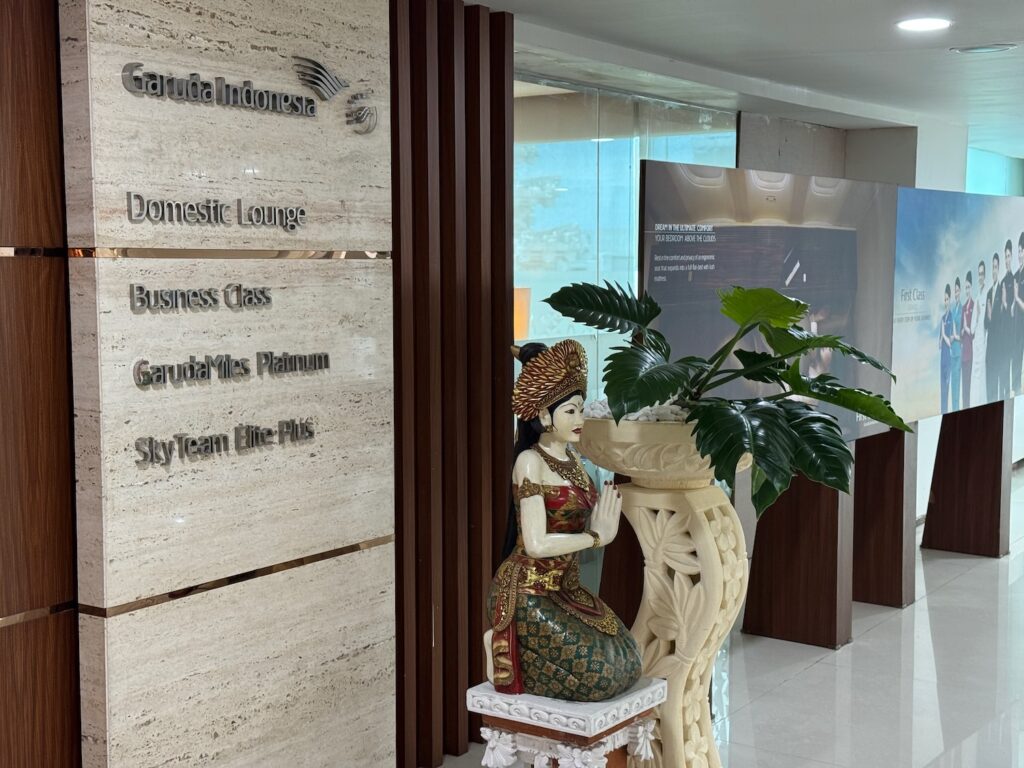 Review: Garuda Indonesia Domestic Lounge Bali (DPS) a statue of a woman in a suit sitting on a pedestal