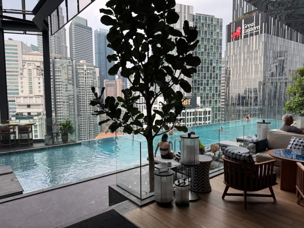 a pool with a tree and a woman sitting on a table