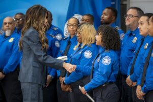 Report: Kristi Noem Moved To Shut Down TSA PreCheck Without White House Approval a woman shaking hands with police officers