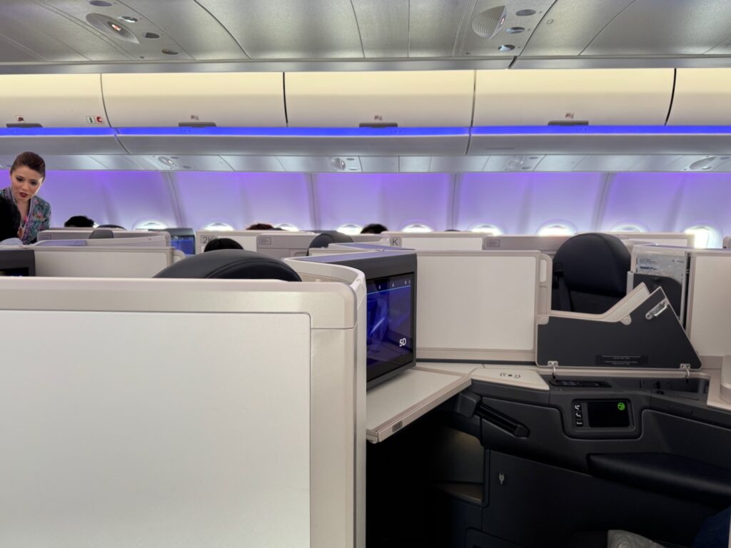 A Note To The Newlyweds In Business Class On My Malaysia Airlines Flight a row of seats with a television on the side