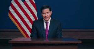 U.S. Tells Americans To “Depart Now” From 14 Middle Eastern Countries — But Offers No Evacuation Plan a man in a suit and tie sitting at a desk