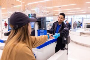 a woman handing a woman a hand to a man at a check-in counter