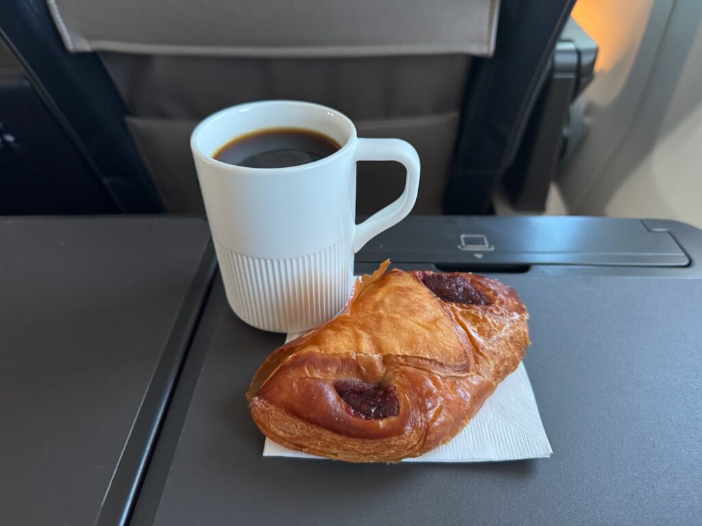 United’s Raspberry Croissant Pocket Is A Small First Class Touch That Actually Works a pastry and a cup of coffee