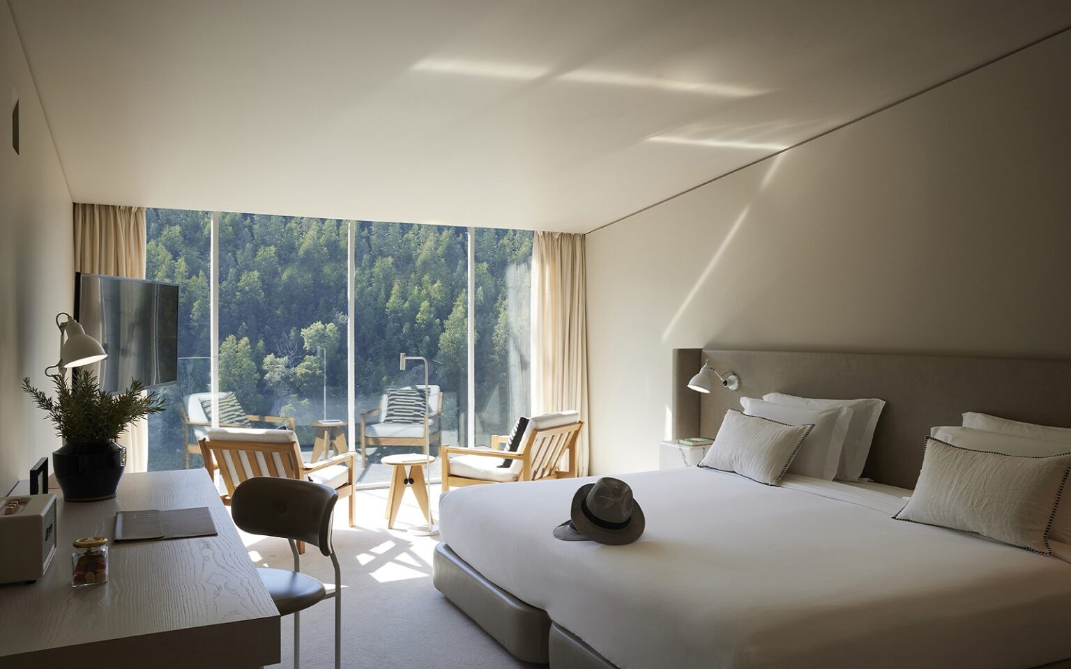 view from guestroom with floor to ceiling glass over to mountainside