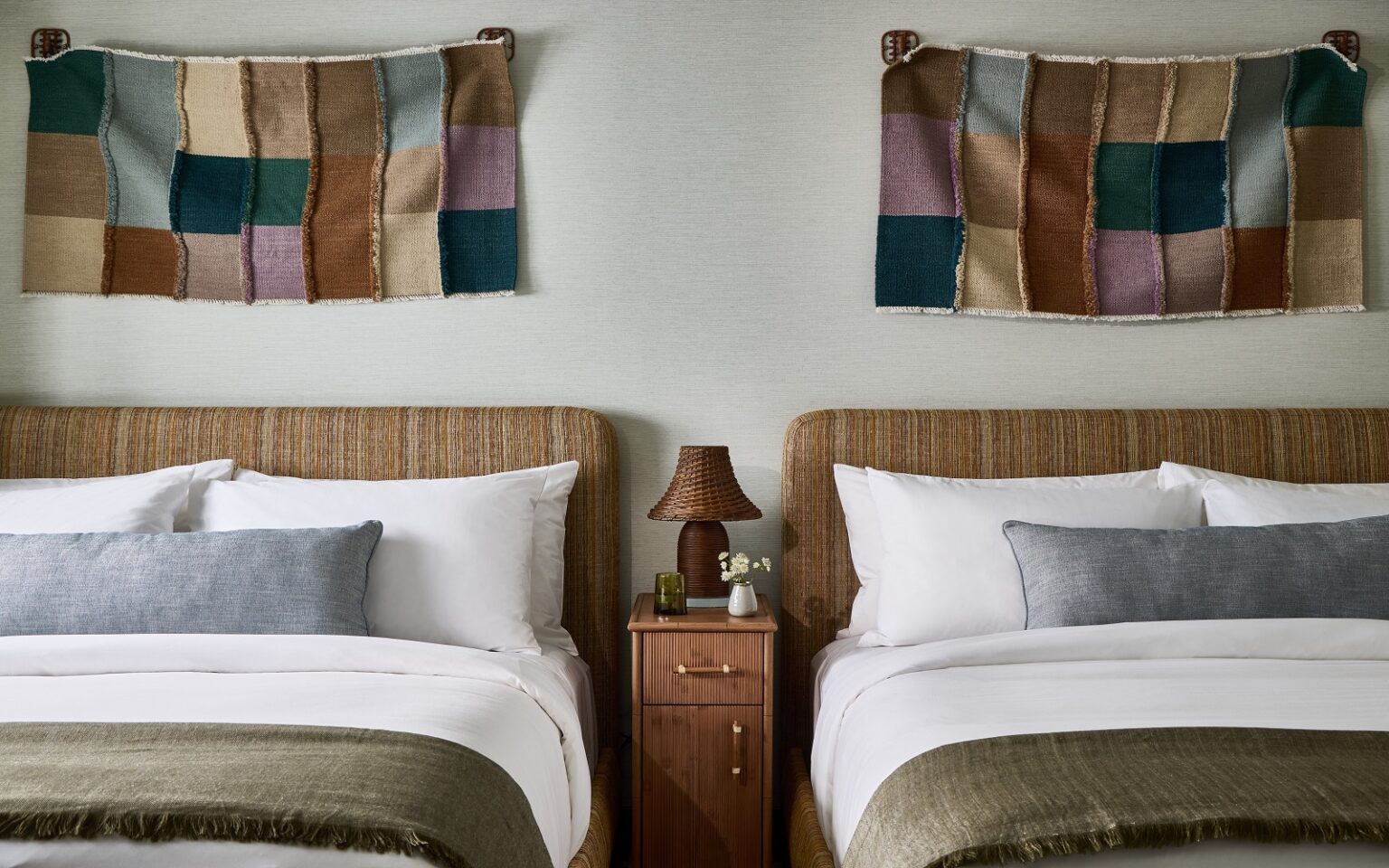 Hotel Corduroy – a coastal retreat rooted in Montauk’s surf culture and community 2 beds in Hotel corduroy with decorative textile wallhanging behind