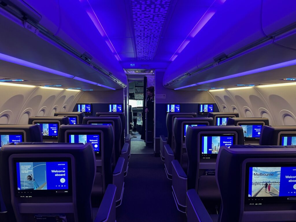 United Airlines Pilots Fired After “VIP” Passenger Enters Cockpit During Flight, But The Problem Goes Deeper a row of seats with monitors on the side