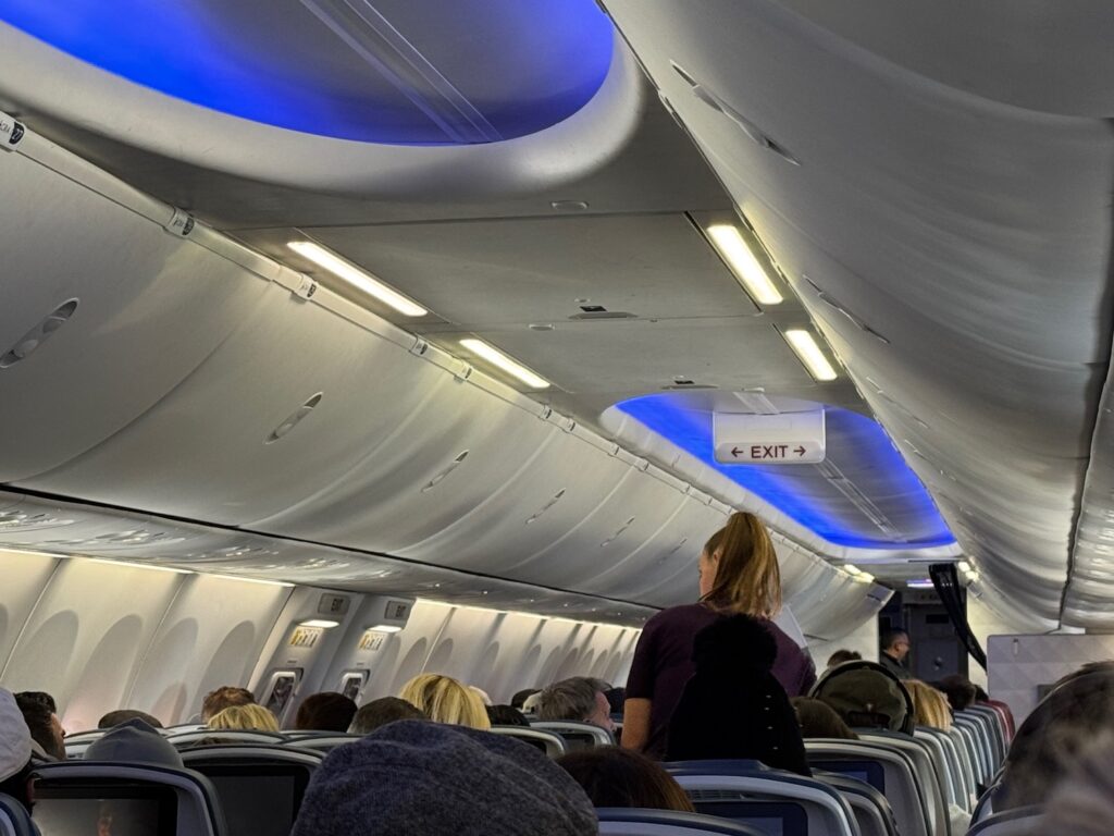 Delta Flight Diverts After Passenger Slaps Flight Attendant’s Butt Over Missed Drink a group of people sitting in an airplane