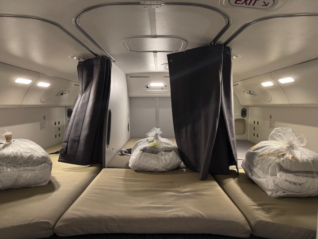 United Airlines Flight Attendants Can Now Sleep In Secret Bunks Instead Of Jumpseats a room with white bags and black curtains