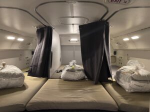 United Airlines Flight Attendants Can Now Sleep In Secret Bunks Instead Of Jumpseats a room with white bags and black curtains