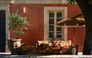 Villa Augusta – a home before a hotel pink plaster, umbrella and couch outside villa augusta