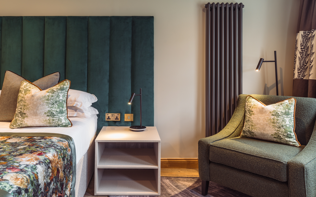 Designing Atmosphere: how lighting control shapes the guest experience green upholstered headboard in hotel guestroom with Hamilton Litestat fittings