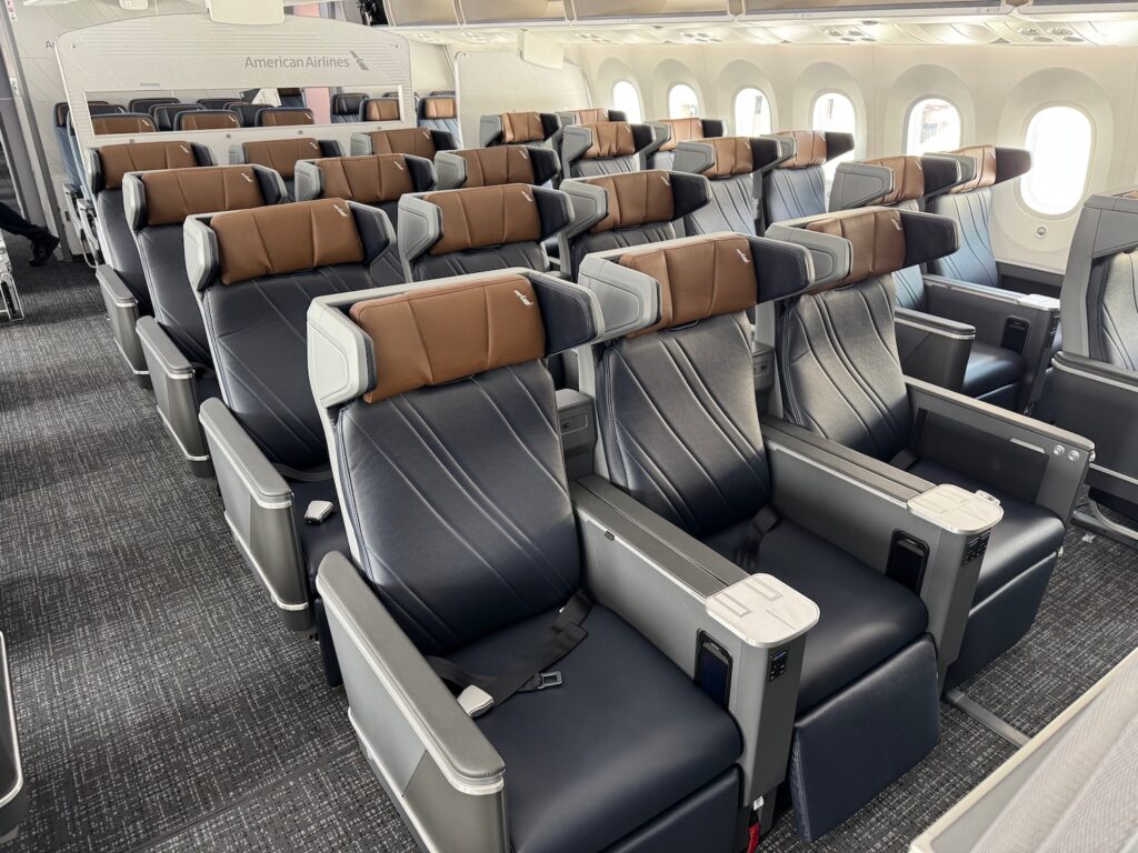 American Airlines Quietly Downgrades Elite Upgrades On Premium Domestic Routes a row of seats in an airplane
