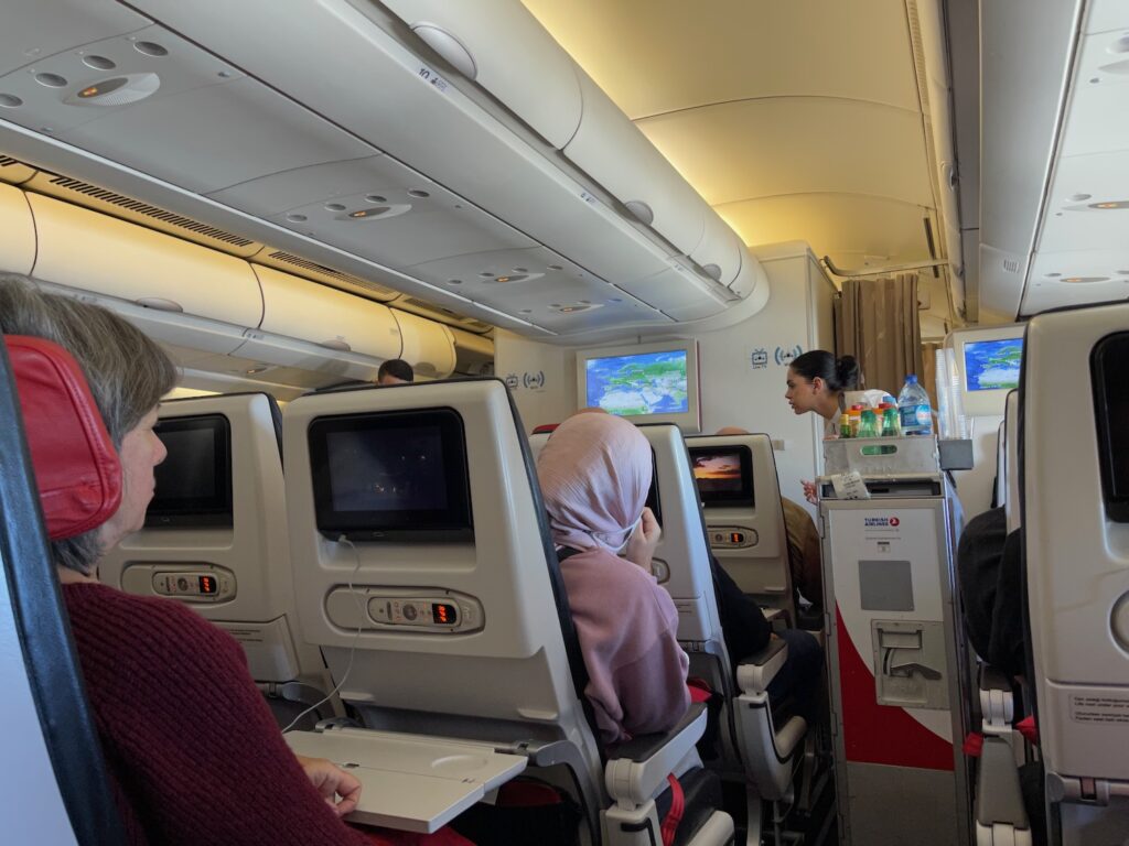 She Refused To Trade Her Aisle Seat For A Middle, Then Says The Other Passenger Cried For Three Hours a group of people sitting in chairs on an airplane