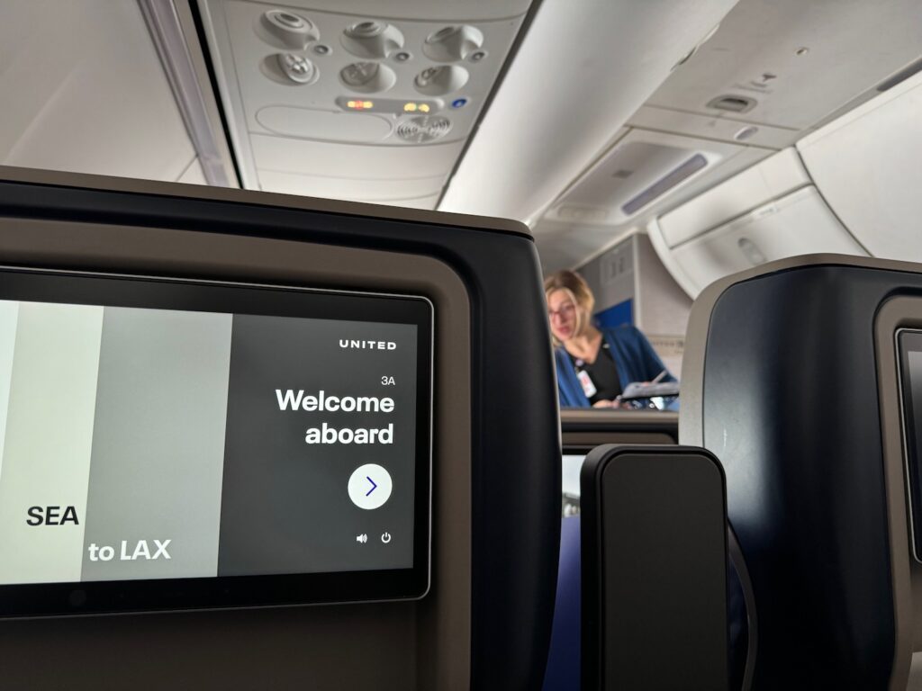 United Airlines Launches Basic First Class With Punitive Change Fees And Zero Award Miles a screen on an airplane